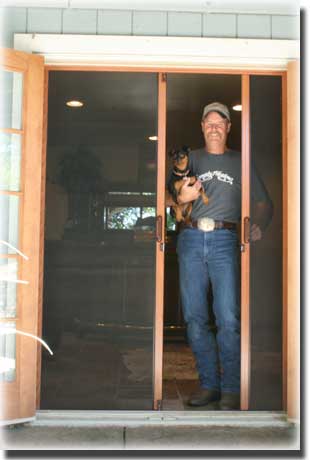 man in jeans and hat standing in doorway of sliding doors