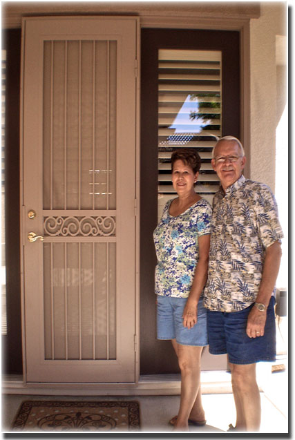 older couple standing in front of white security door