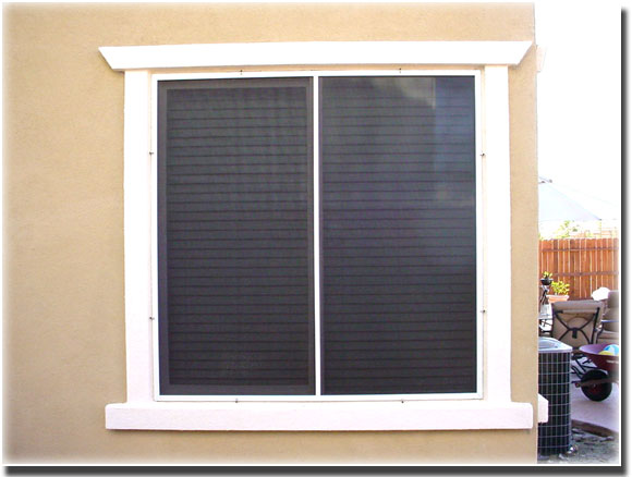 Brown Day Time Privacy Screens installed on two windows of a home  trim of windows is white