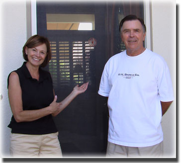 woman in black shirt and man in white shirt standing in front of new screen door