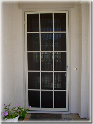 close up of white front door of home with rows of three windows in it