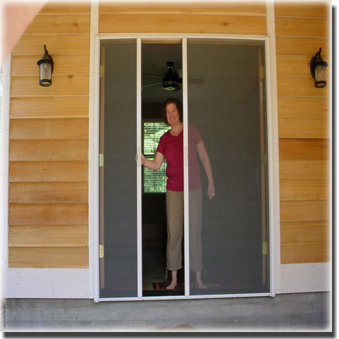 Woman standing in doorway of french screen doors