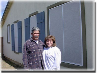 couple standing in front of newly screened windows in their home
