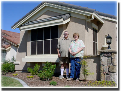middle age couple standing in front of home and screened windows