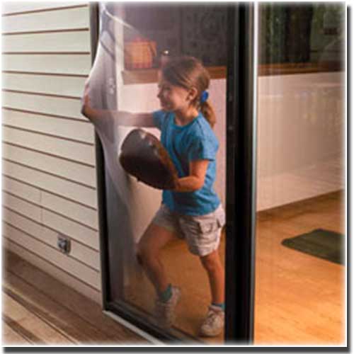 young girl wearing a baseball fit pushing into a screen of sliding door