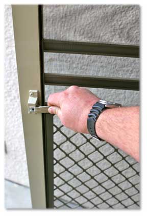 Man's hand wearing a watch opening a  Screen Door Handle