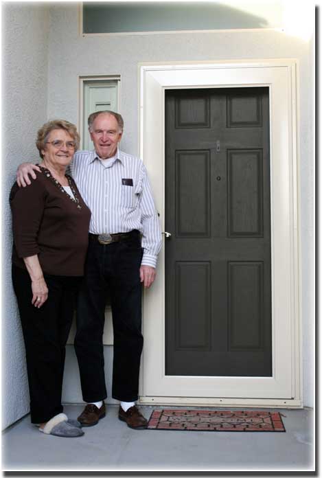 older couple standing in front of screen doors