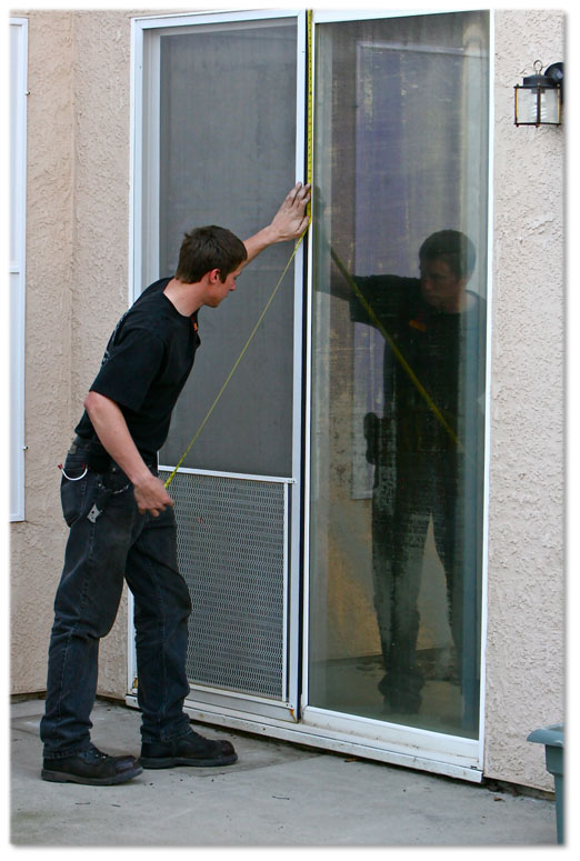 Man in black clothing taking measurements of windows