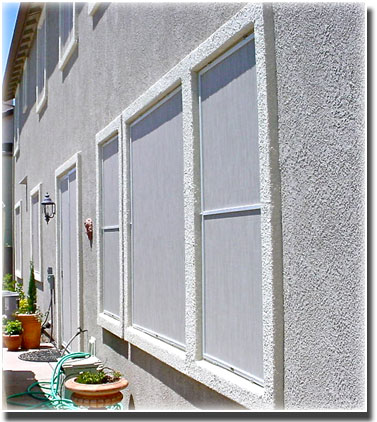 Stucco Window Privacy Screens in windows of a home with potted plants in front of them