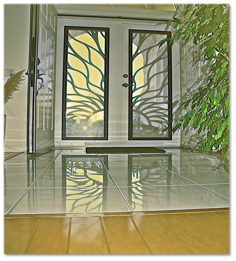 Two large white security screen doors in home with tiles in the front of it reflecting back doors image