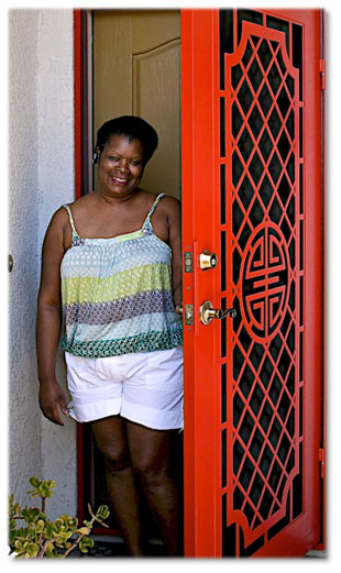 Woman standing in front of red security screen door