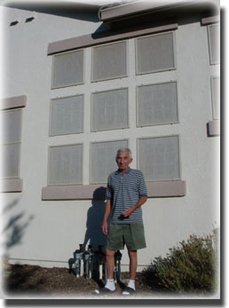 older man in shorts standing in front of security windows
