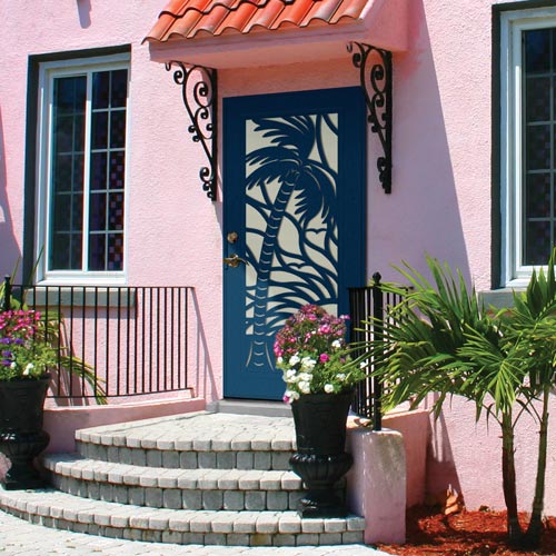 pink home with navy blue colored security door with palm tree design steps and plants out in front of it