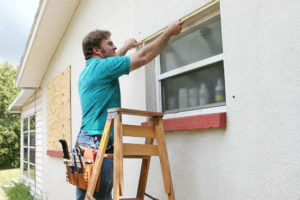 man measuring window