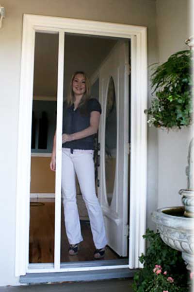 Woman in black shirt and white pants standing in doorway 
