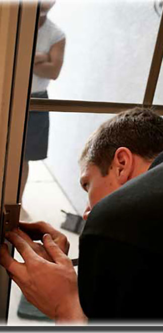 Man working up close to hinges of screen door taking measurements