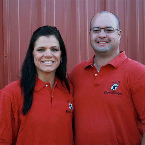 Man and woman wearing red A to Z Screens shirts smiling
