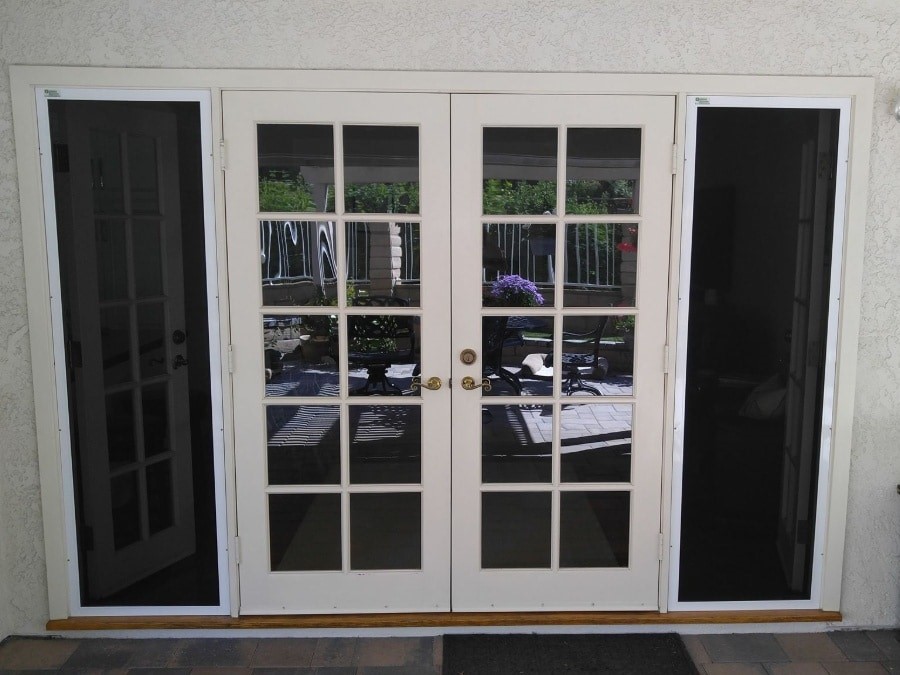Two double doors with black shutters doors have two rows of 5 small windows each